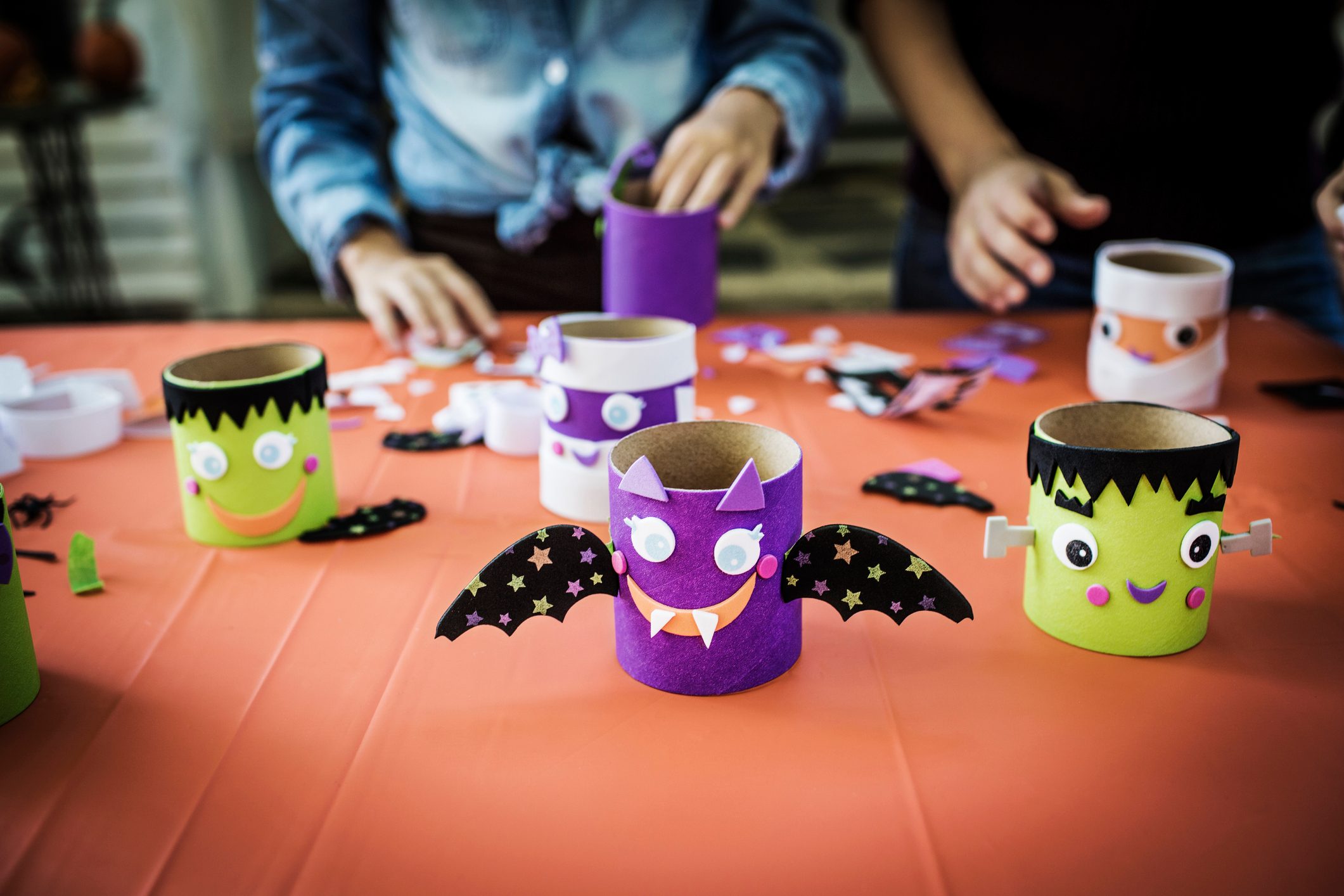 children making toilet paper roll monsters at a halloween party