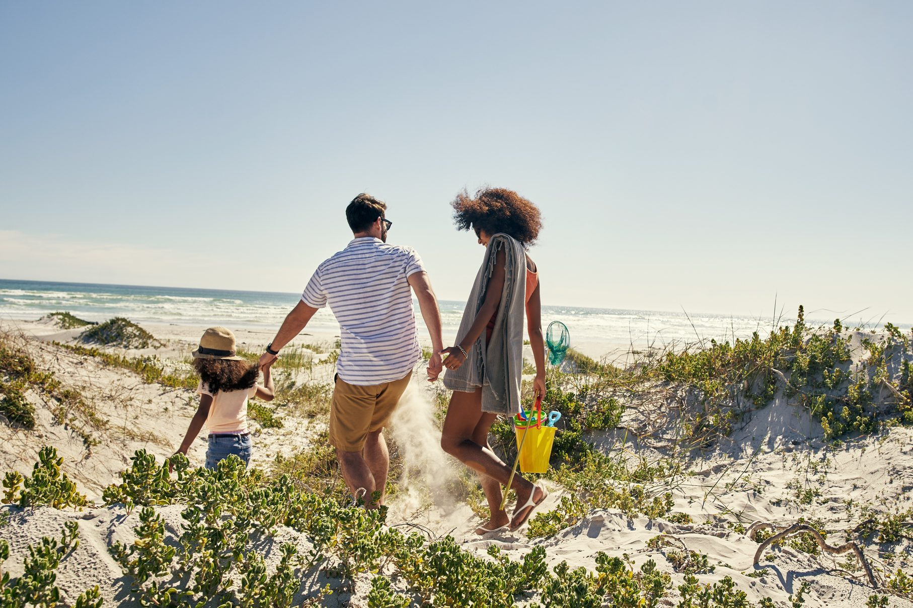 family walking down to the beach on a sunny day