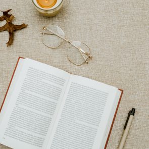 Flatlay of book and fall themed objects on speckled gray background