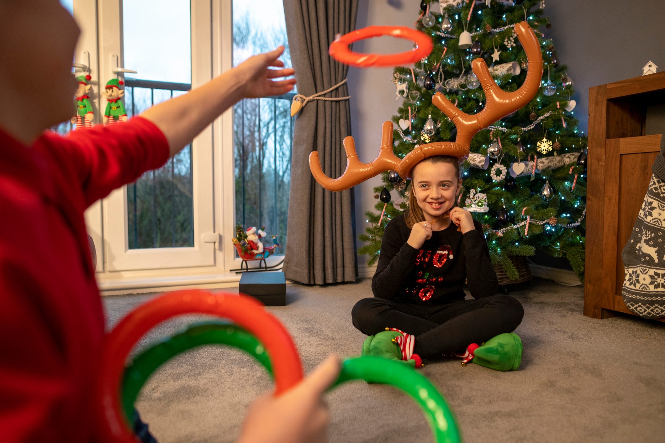 kids playing reindeer antler ring toss game on christmas eve