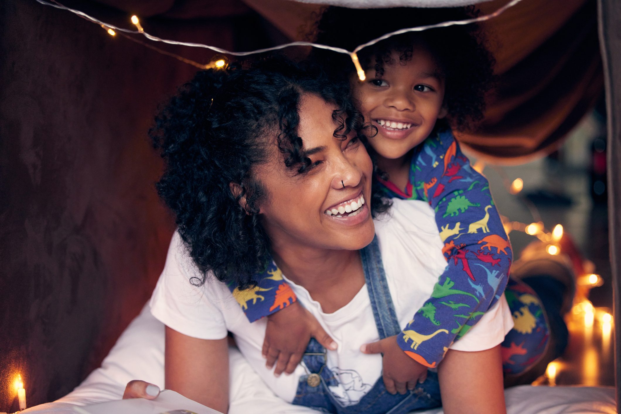 mother and son playing in a pillow fort at home