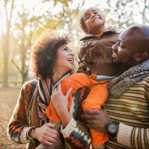 happy family walking through the woods on a beautiful autumn day