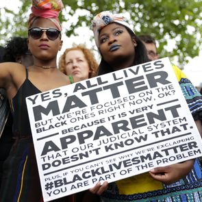 Two women hold a placard with the slogan 