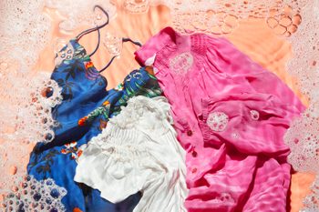 Three silk tops on an orange background with soap bubbles and water effect