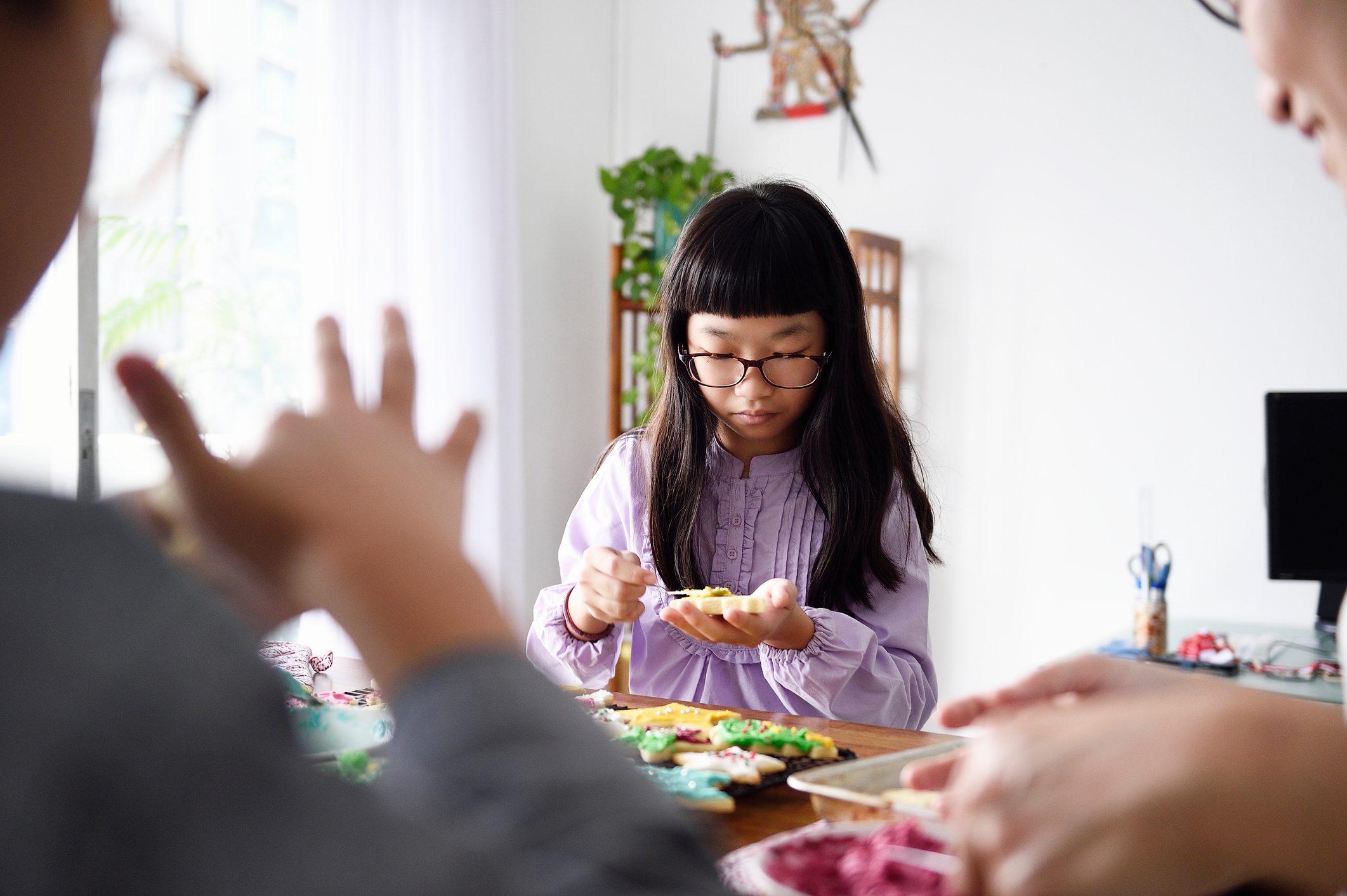 Family decoating sugar cookies together