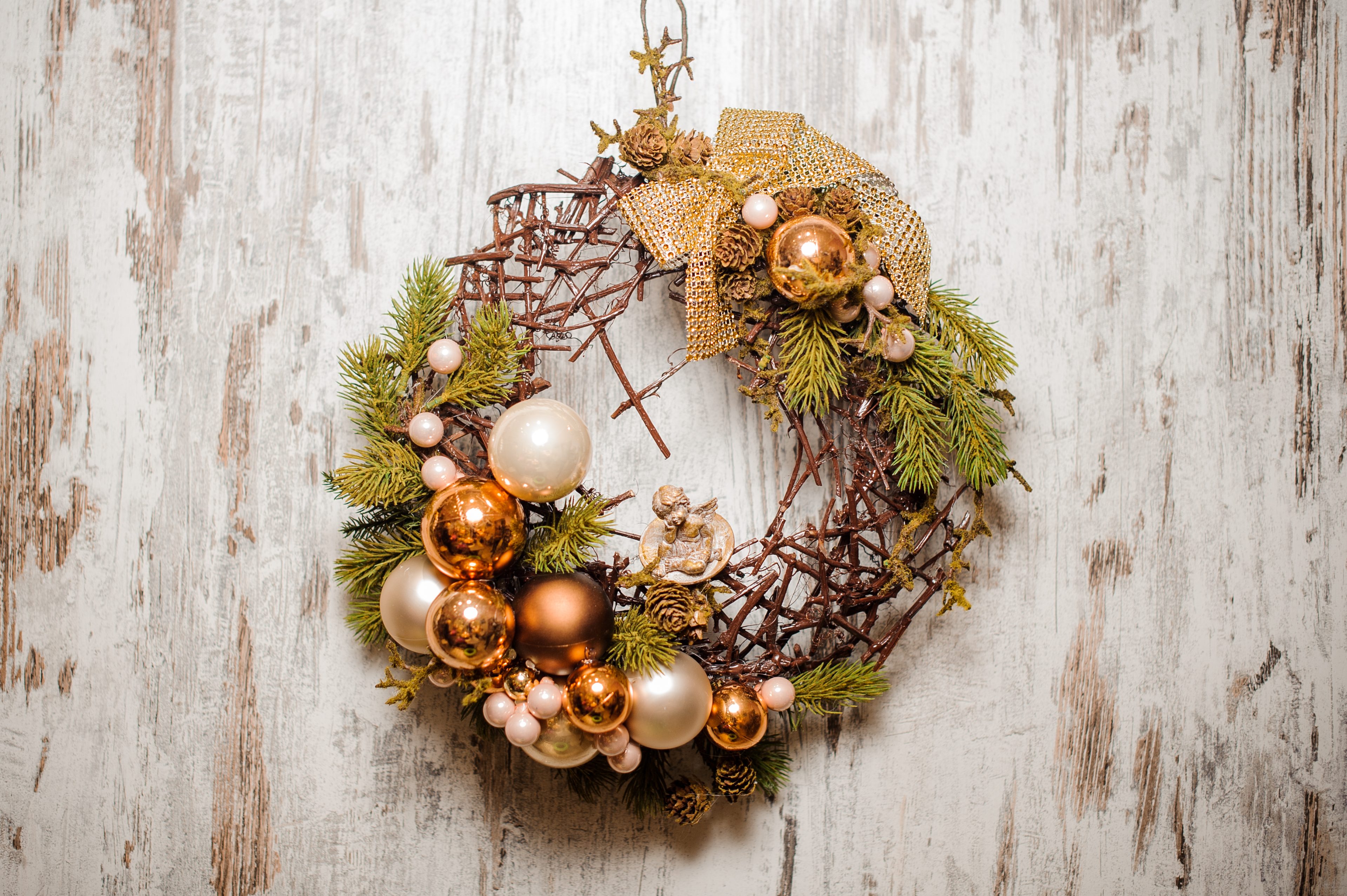 Christmas wreath made of fir tree and branches decorated with golden glass balls and bow