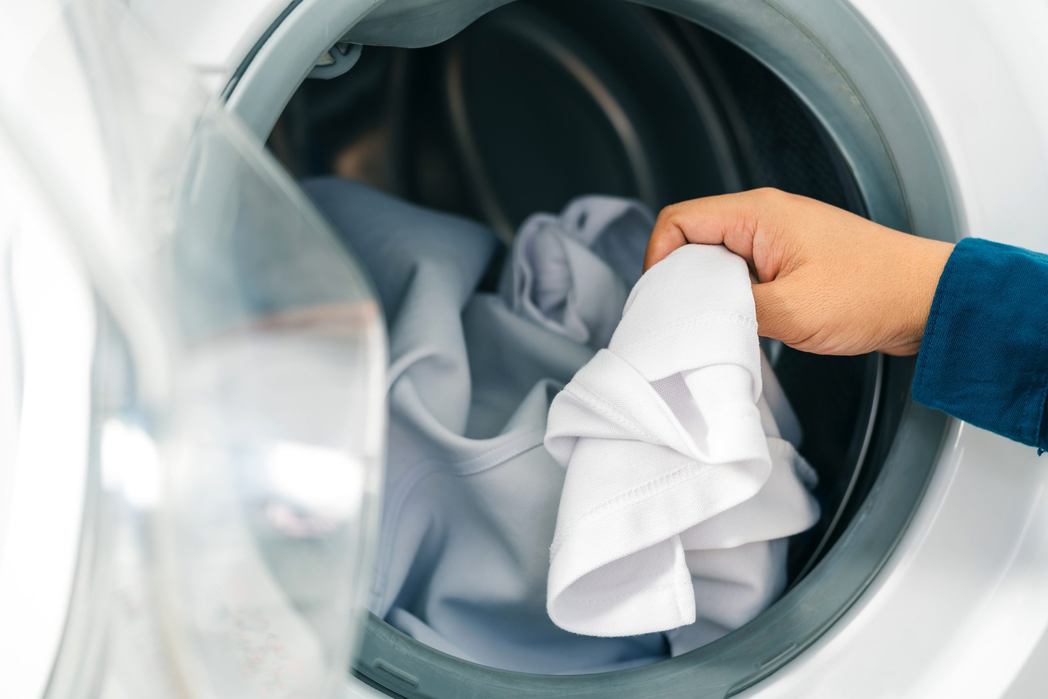 Hand grabbing unwrinkled clothes from dryer