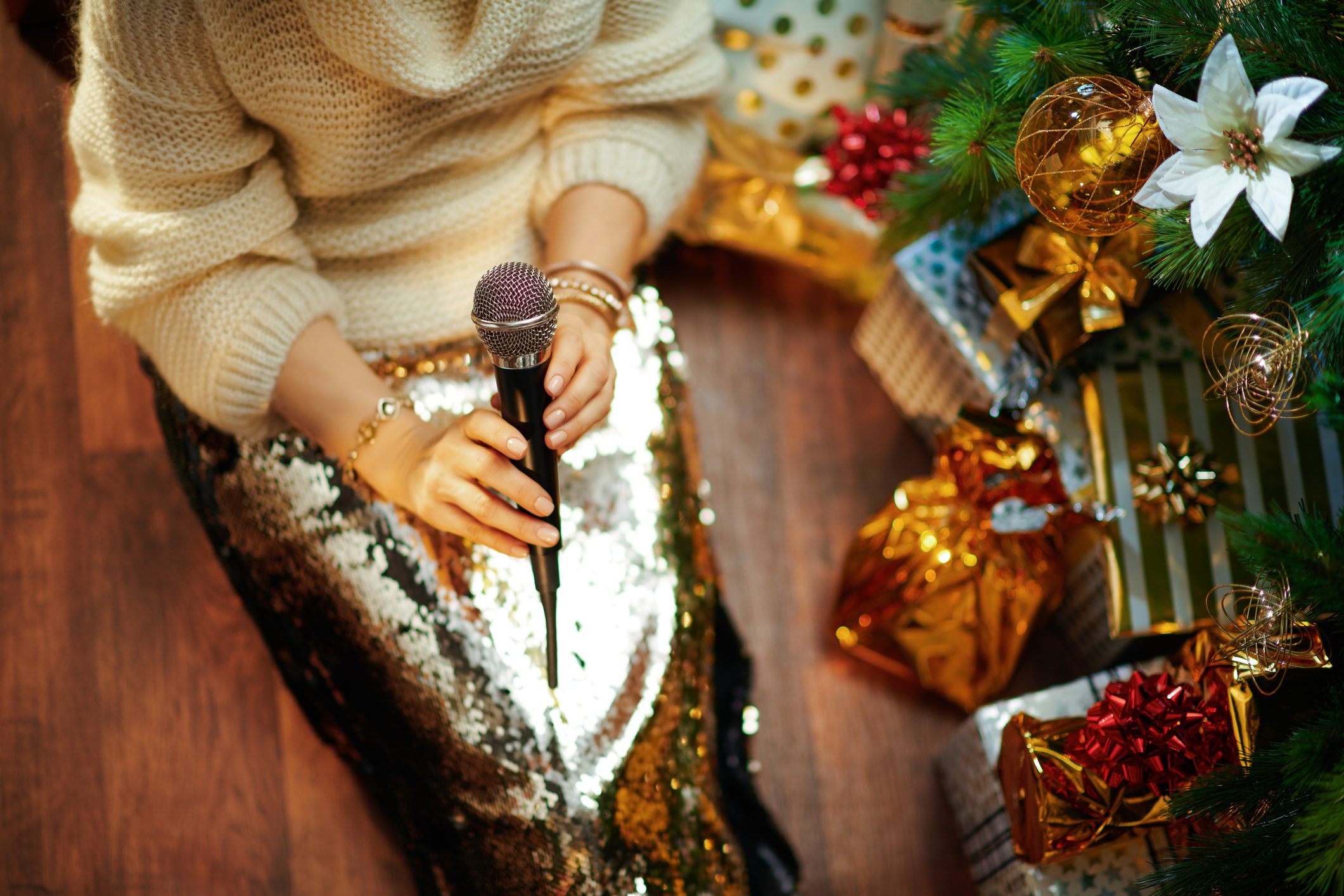 woman holding microphone near christmas tree during holiday party