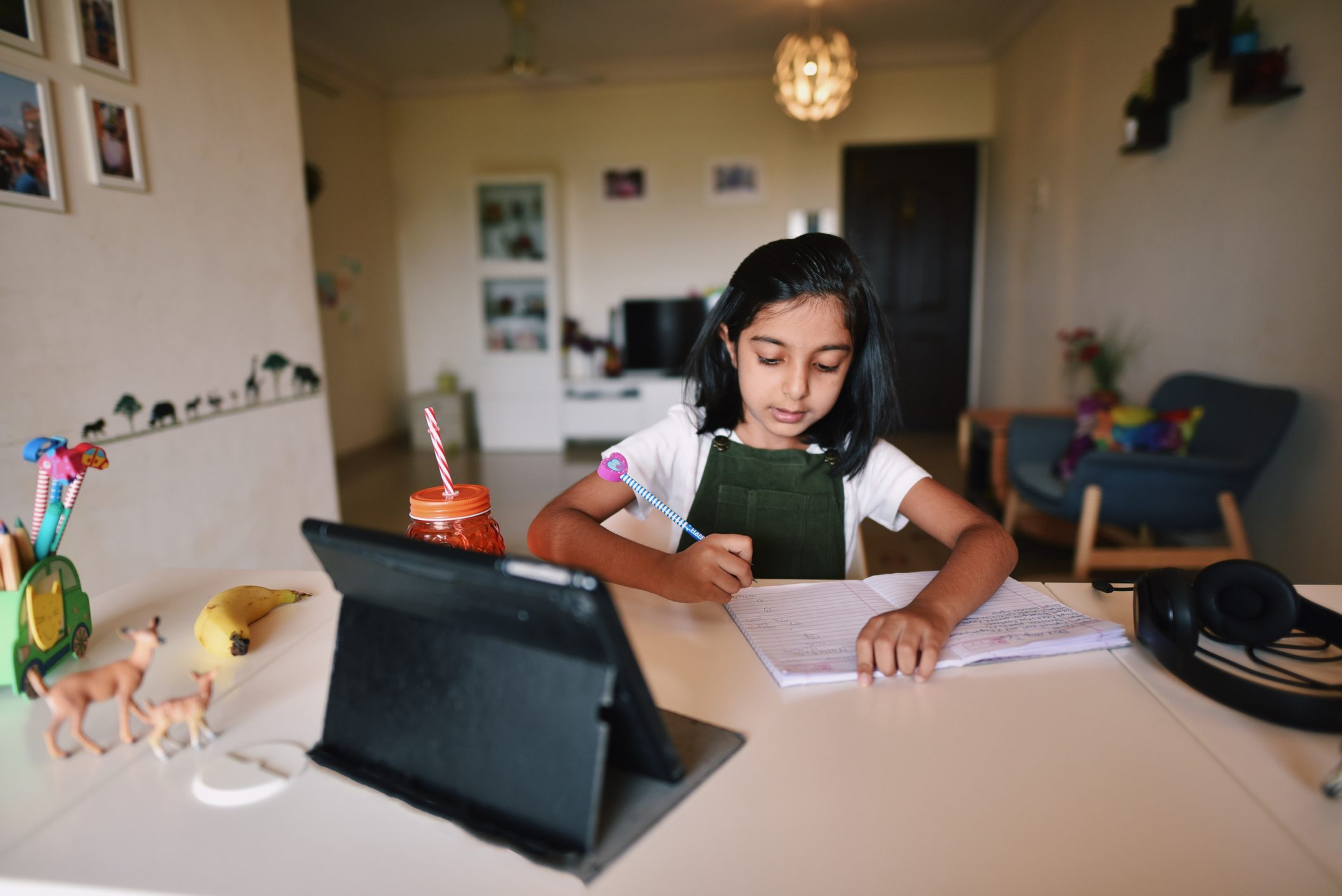 Young girl attending online school with tablet