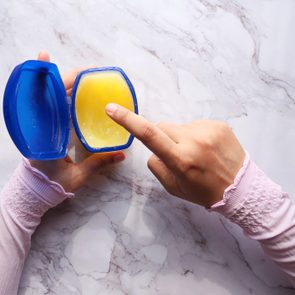 top view of woman's hand using petroleum jelly