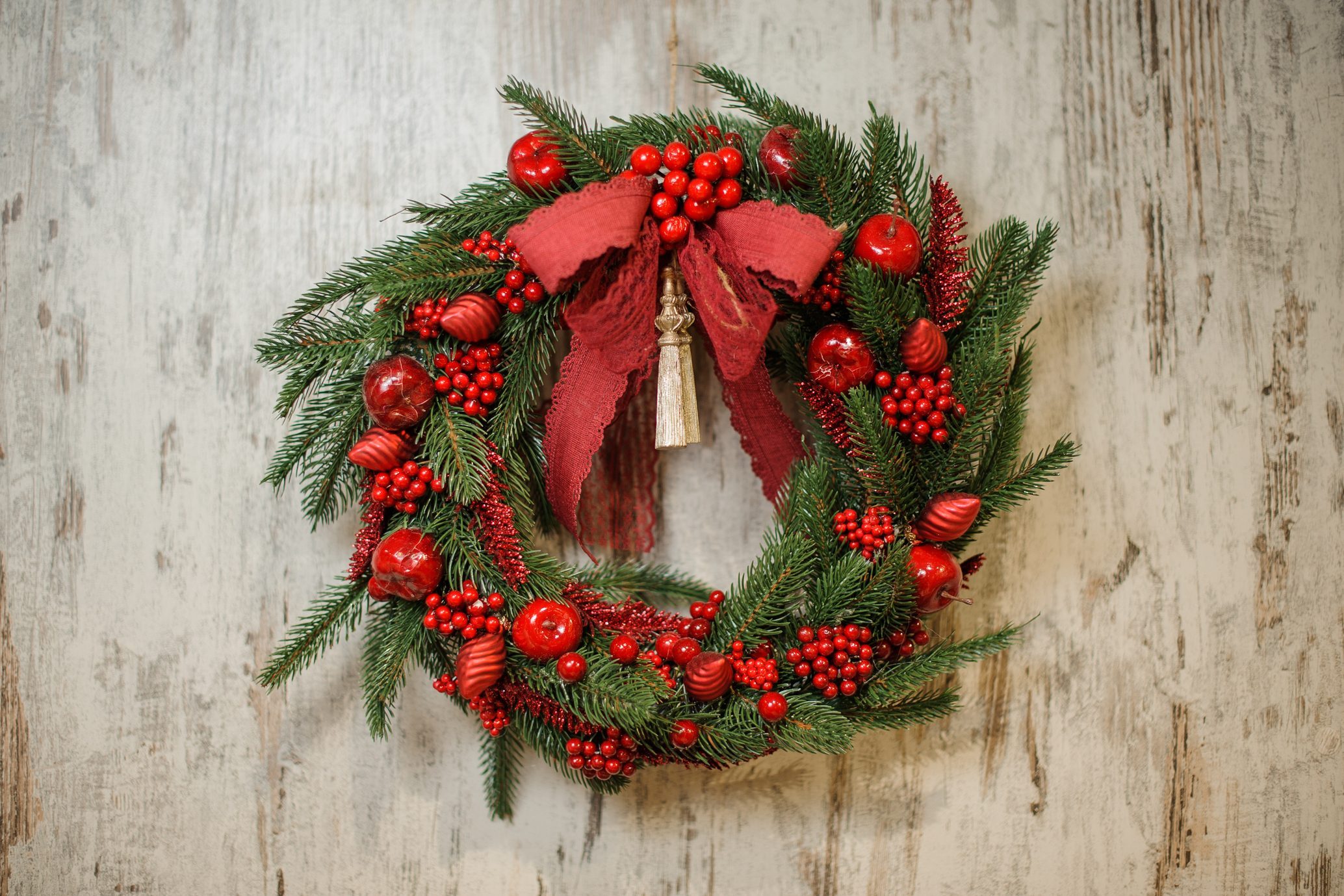 Apples and bow Christmas wreath on wood background