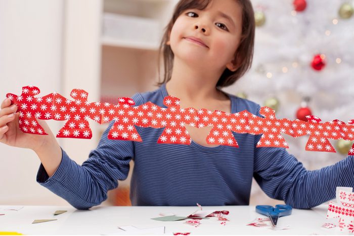 Girl holding Angel garland Christmas decoration, portrait