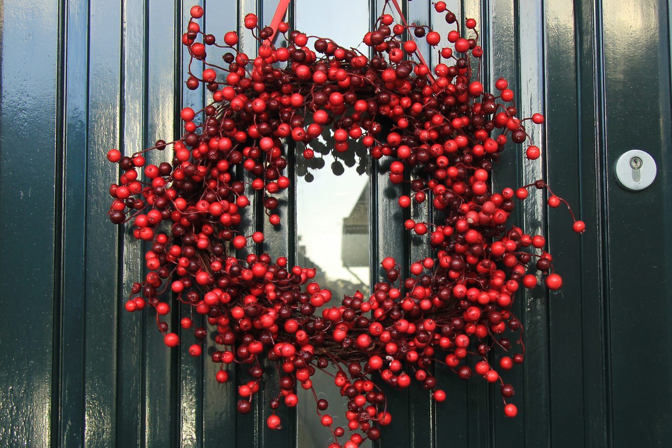 Berry christmas wreath with decorations on a door