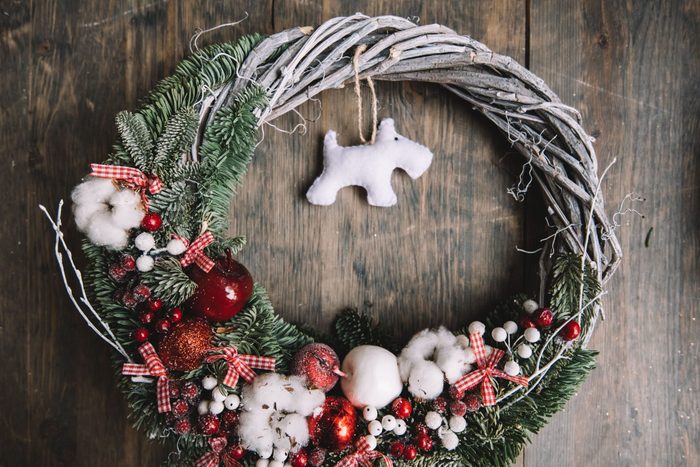 Beautiful festive winter hand made wreath on the rustic wooden table background, top view