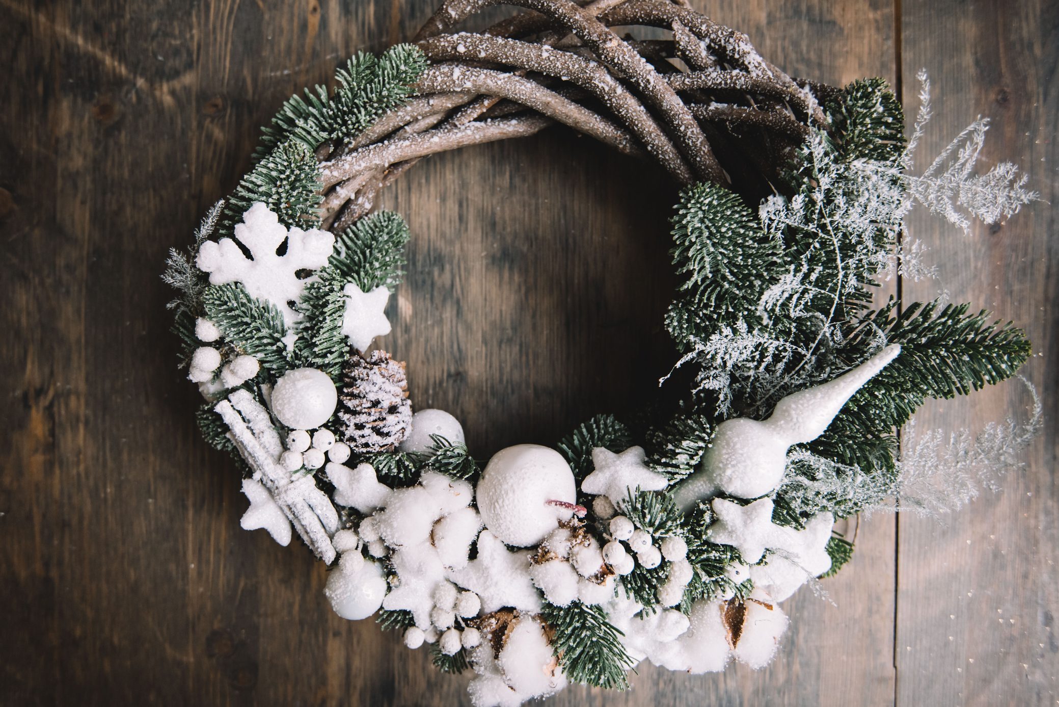 Beautiful festive winter hand made wreath on the rustic wooden table background, top view
