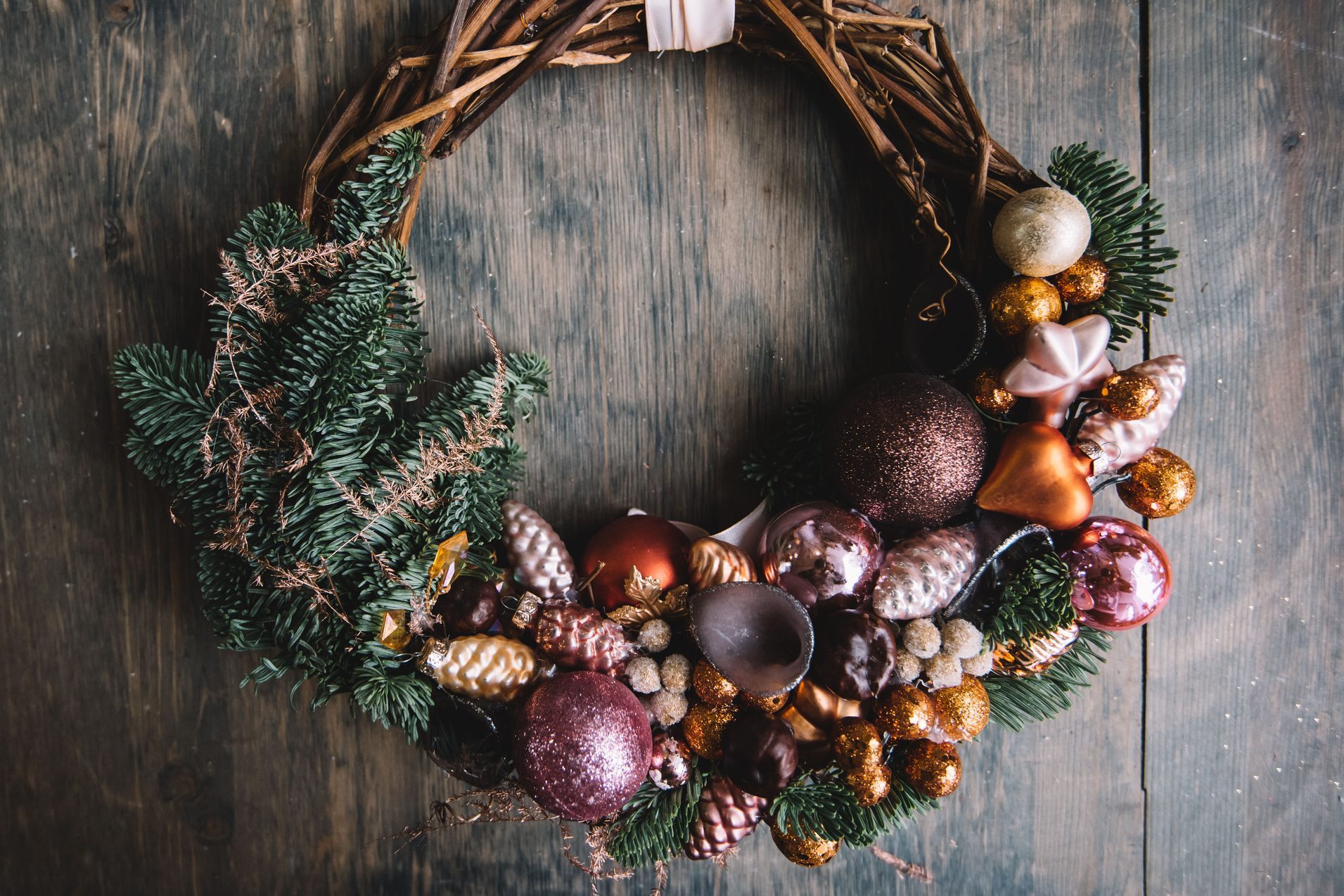 Beautiful festive winter hand made wreath on the rustic wooden table background, top view