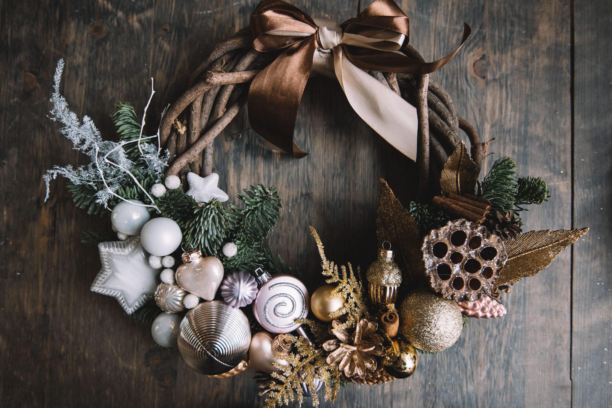 Beautiful festive winter hand made wreath on the rustic wooden table background, top view