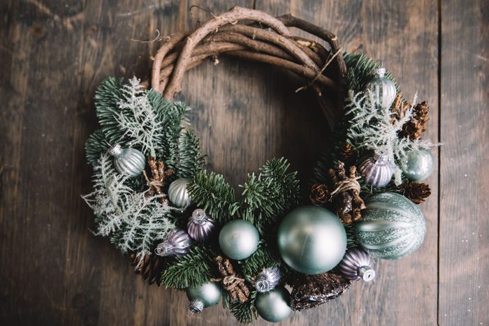 Beautiful festive winter hand made wreath on the rustic wooden table background, top view