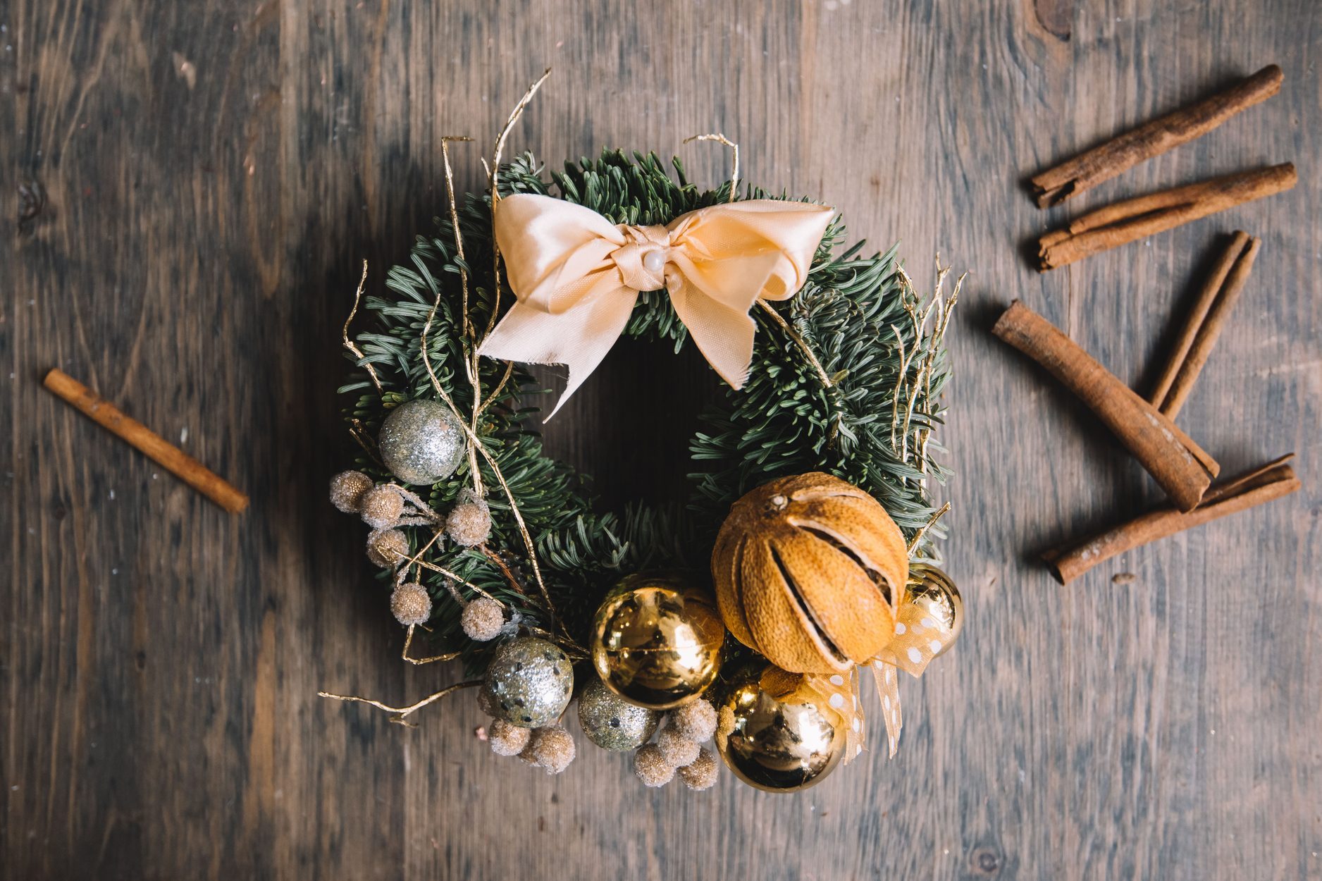 Beautiful festive winter hand made wreath on the rustic wooden table background, top view