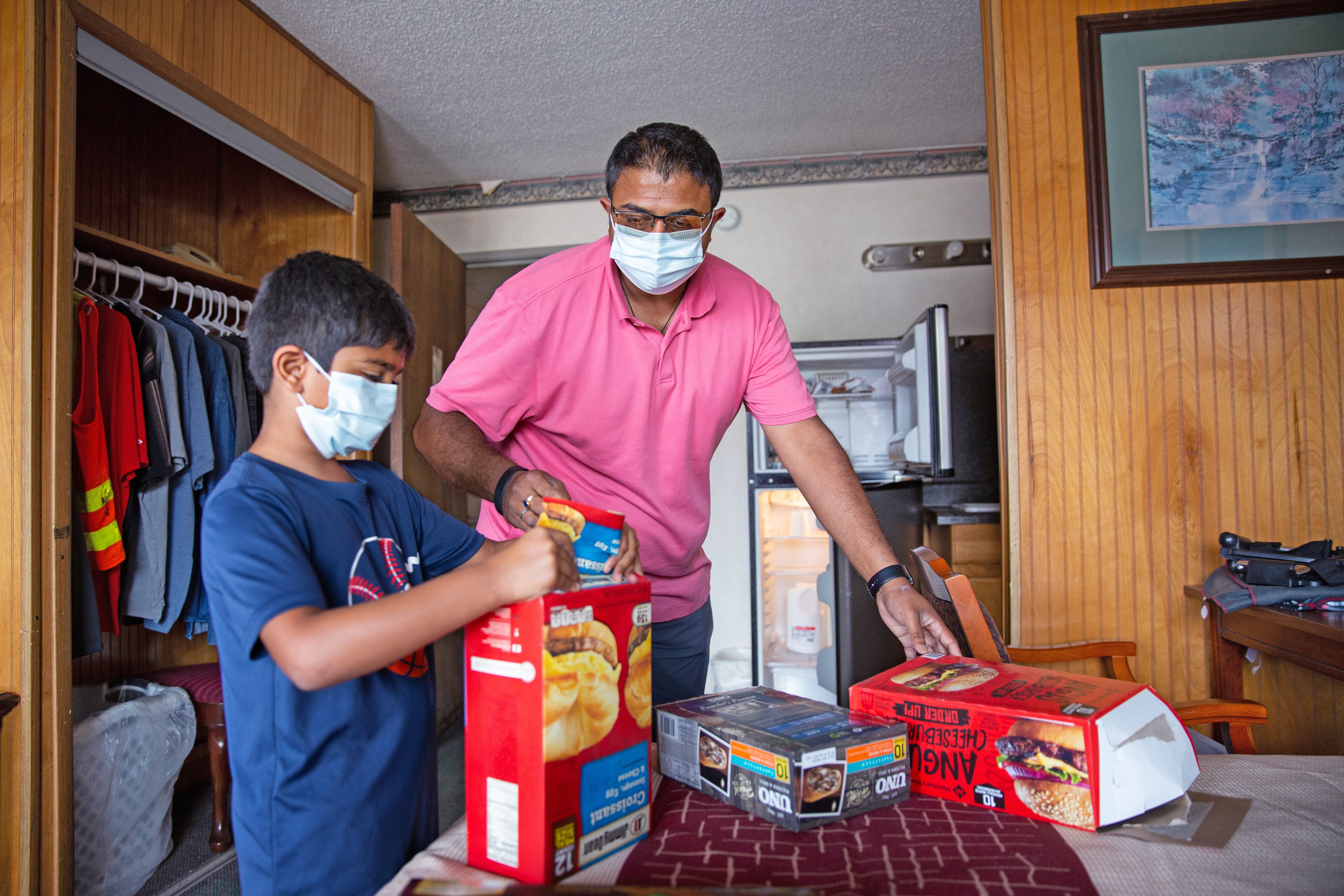 Sean Patel, left, takes down a grocery list for one of his extended stay residents Robert Phelps at the Quality Inn in Kodak, Tenn.