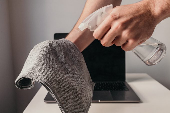 spraying microfiber cloth with cleaner