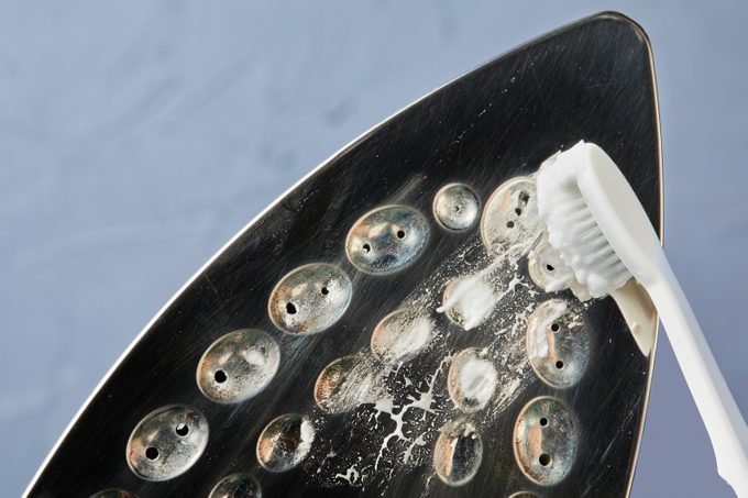Cleaning Iron With Toothbrush and baking soda paste