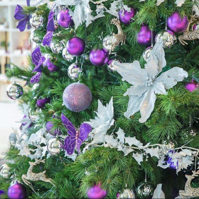 Beautiful decorated Christmas tree theme silver and purple on blurred, sparkling background