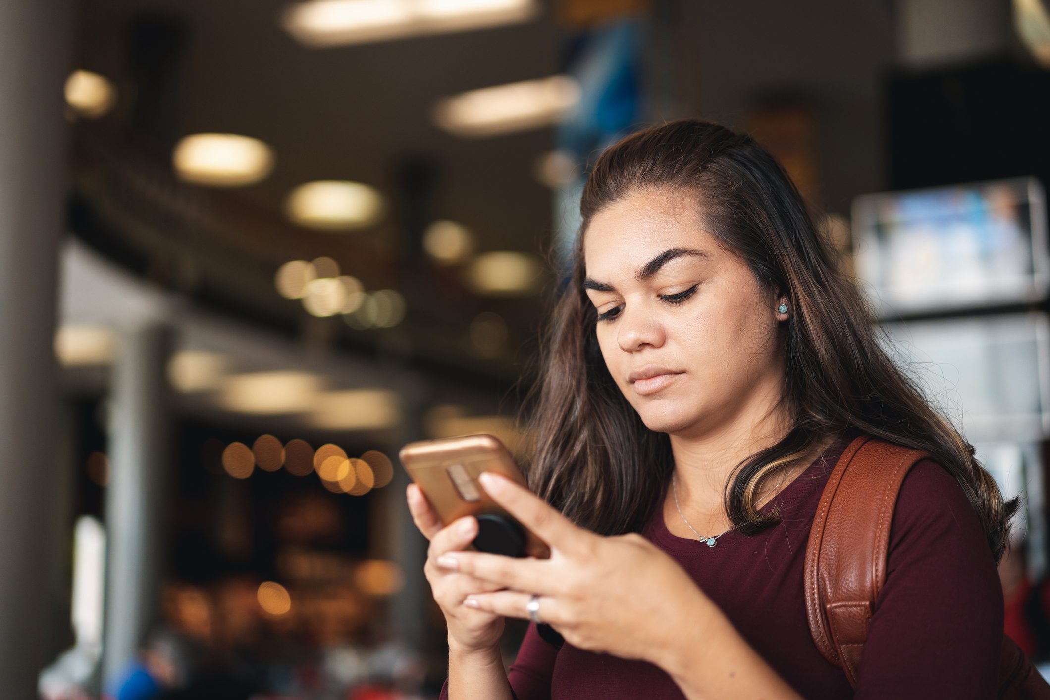 young woman using her smartphone with public wifi