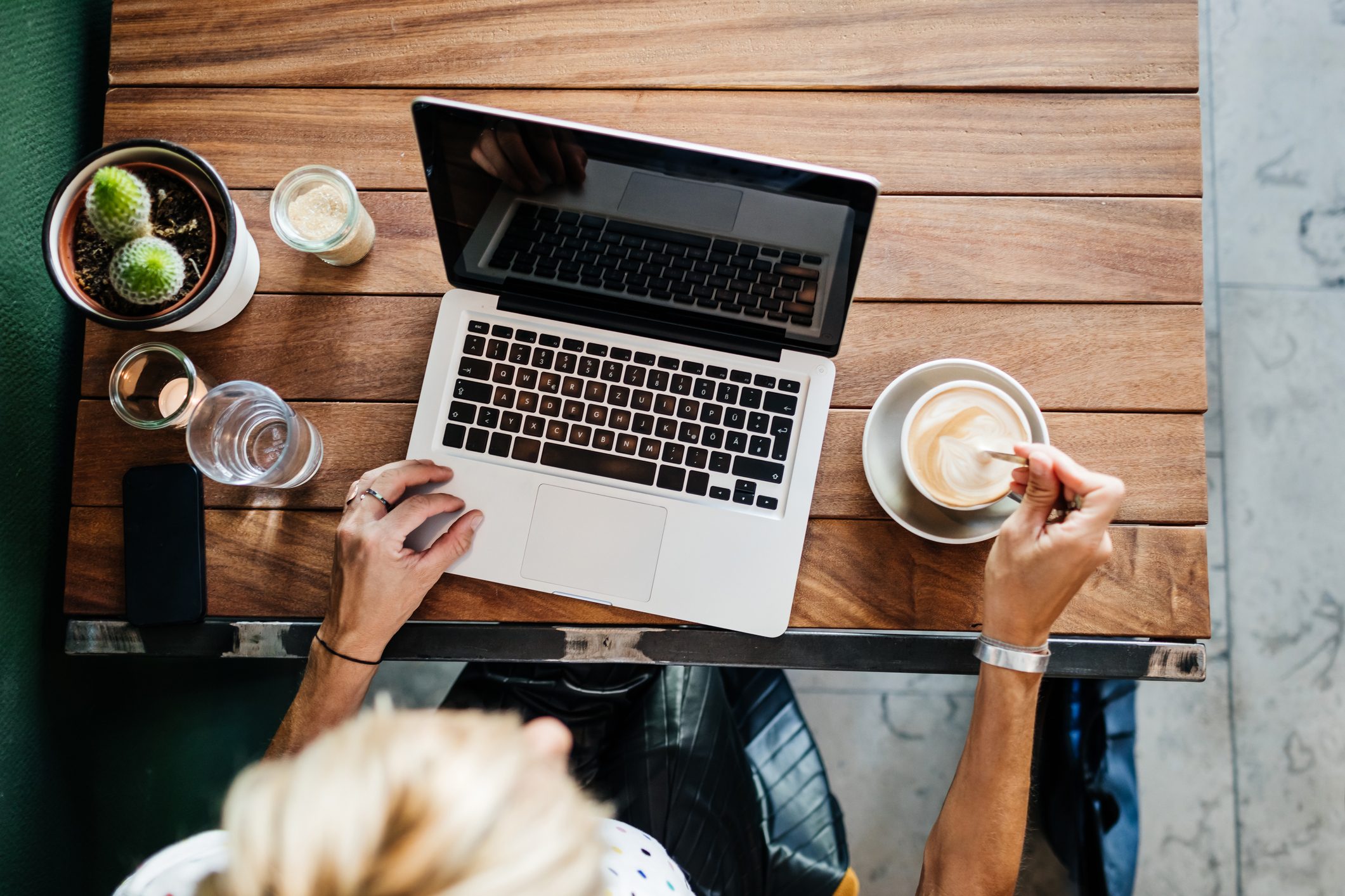 Aerial View Of Woman Using Laptop And Drinking Coffee at a coffee shop