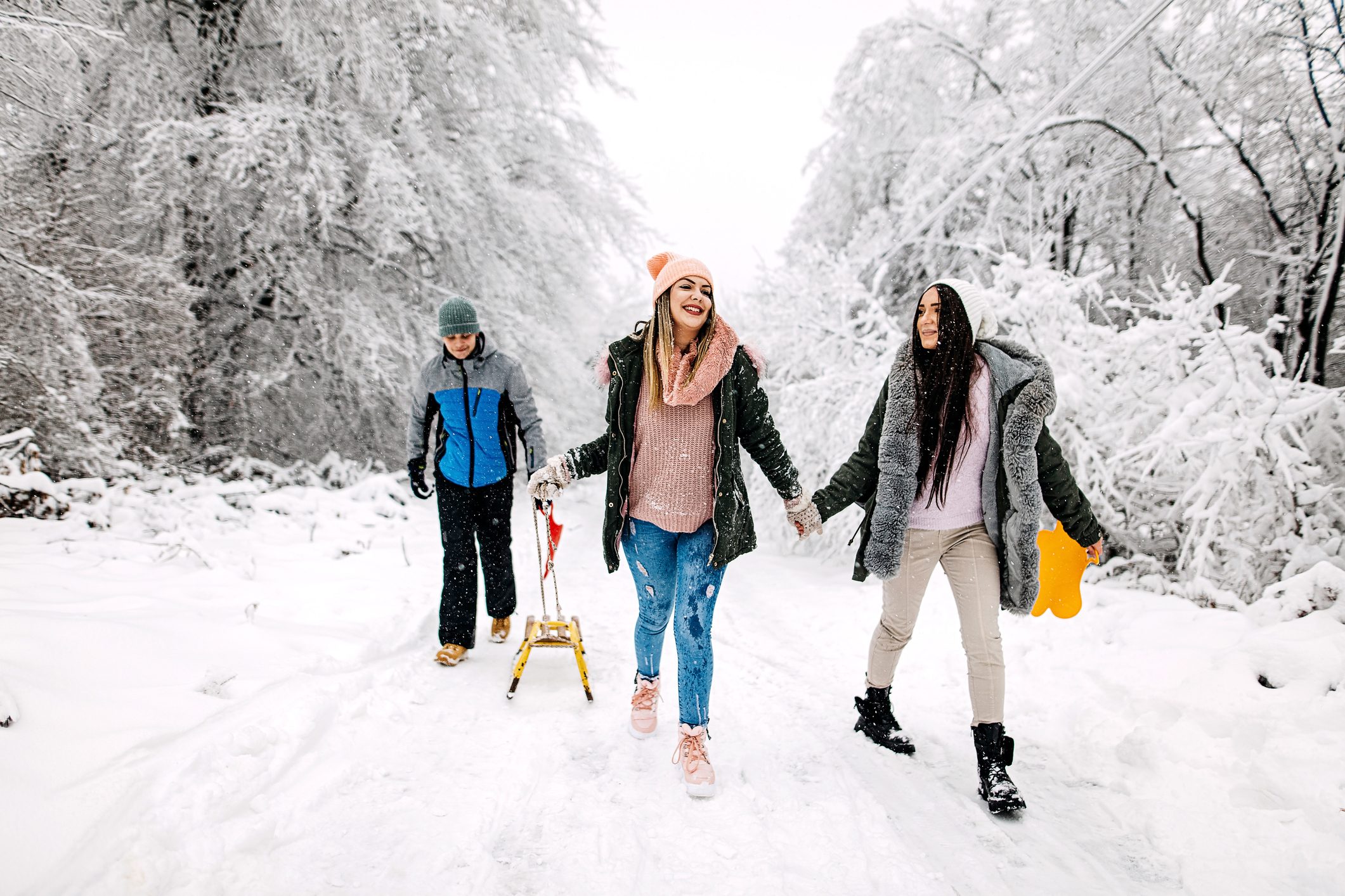 Friends going sledding in the snow