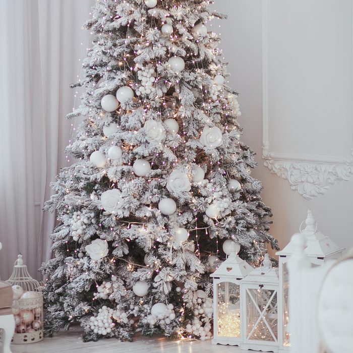 Holiday decorated room with Christmas tree covered with snow and toys