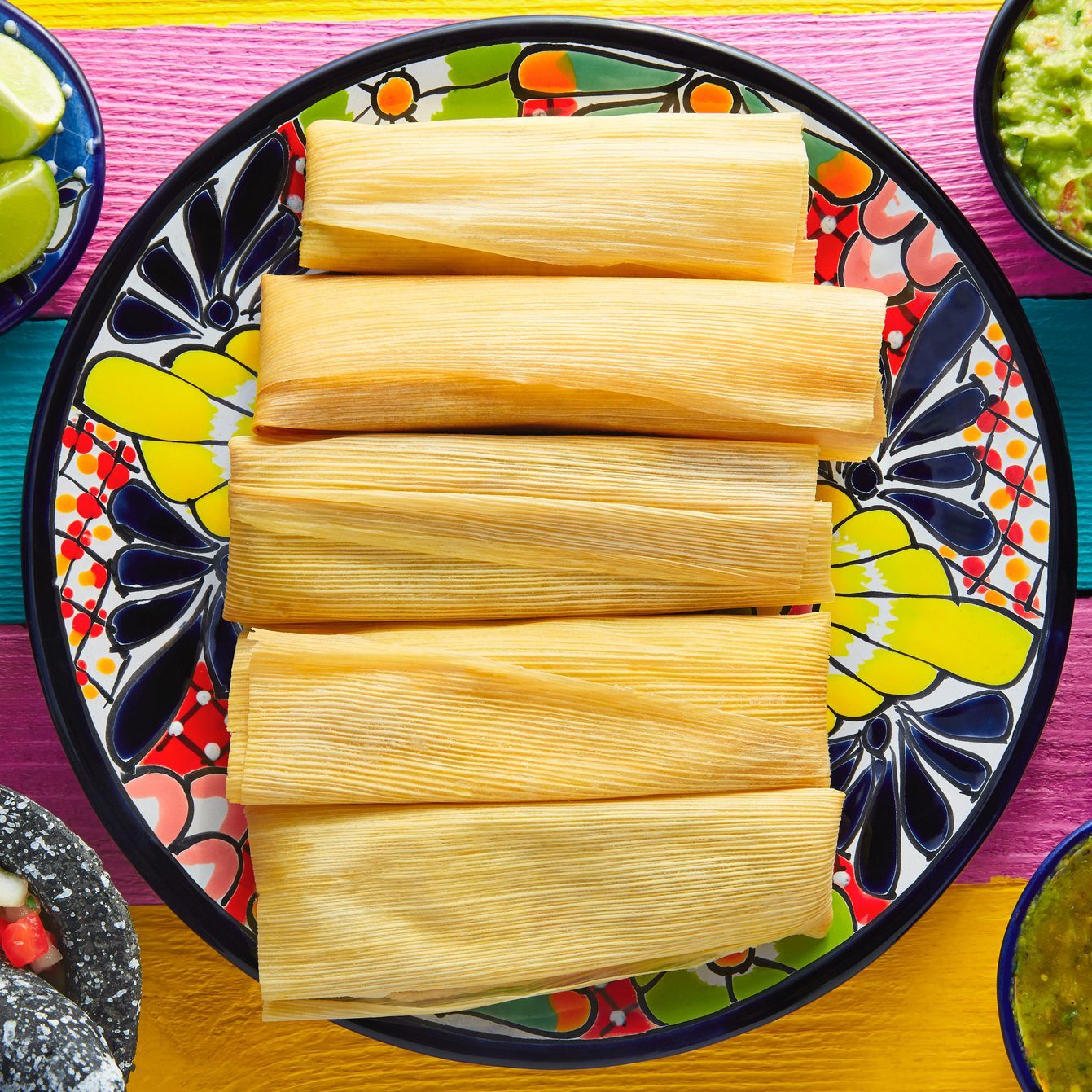 Tamale with corn leaf and sauces guacamole