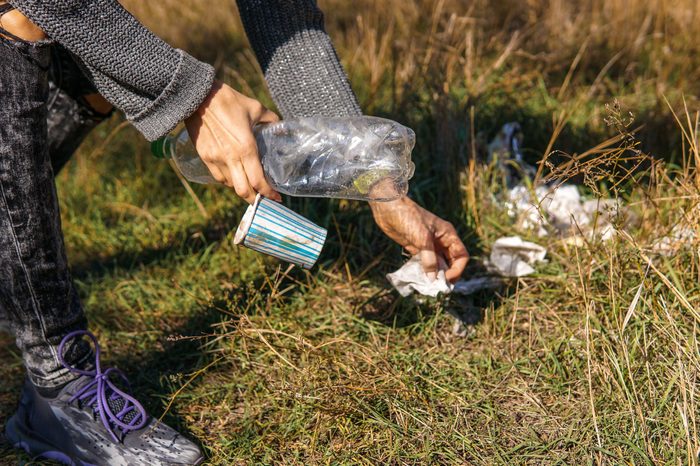 woman picking up trash on the ground