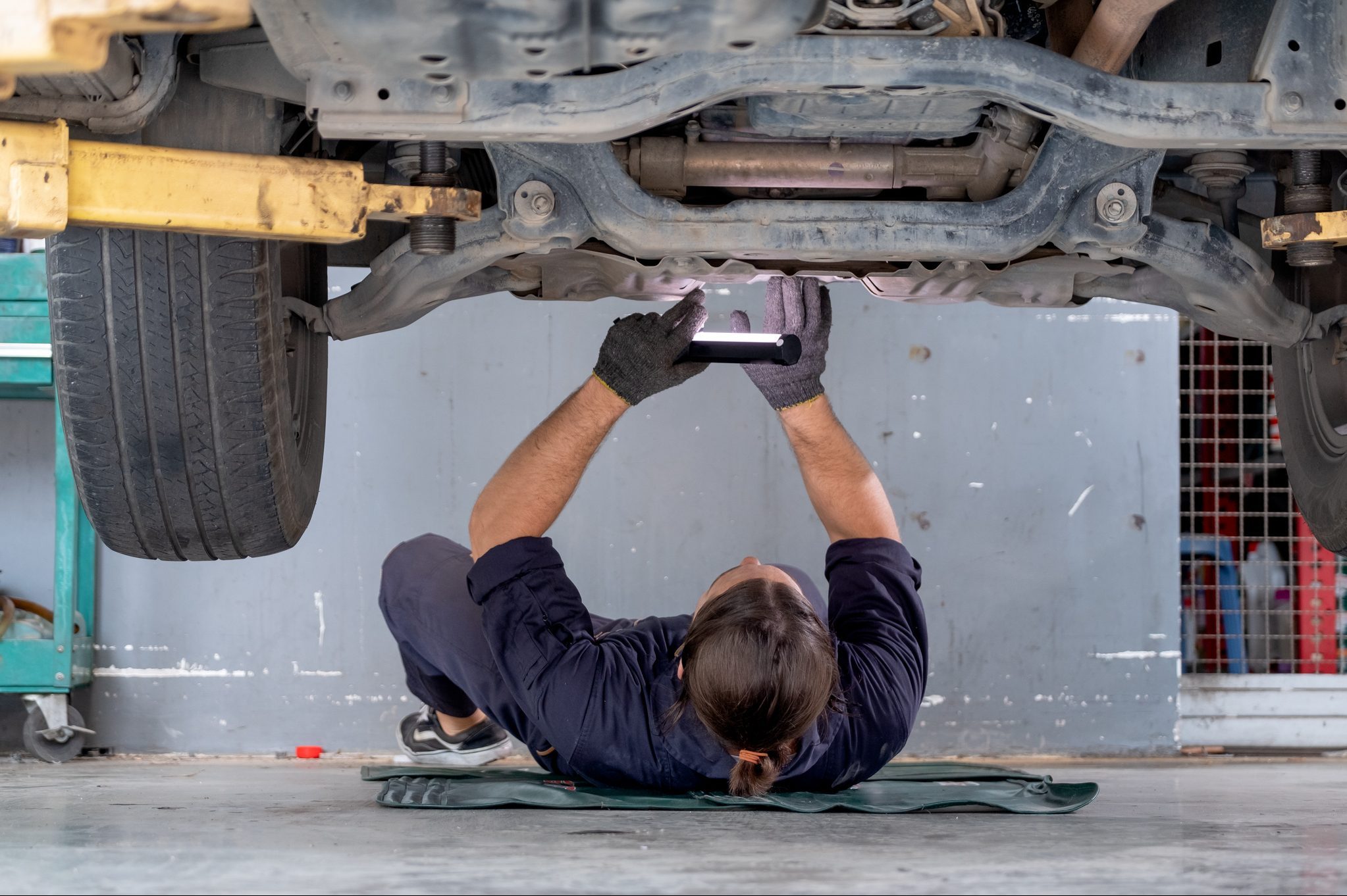 car mechanic working below a bar