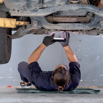 car mechanic working below a bar