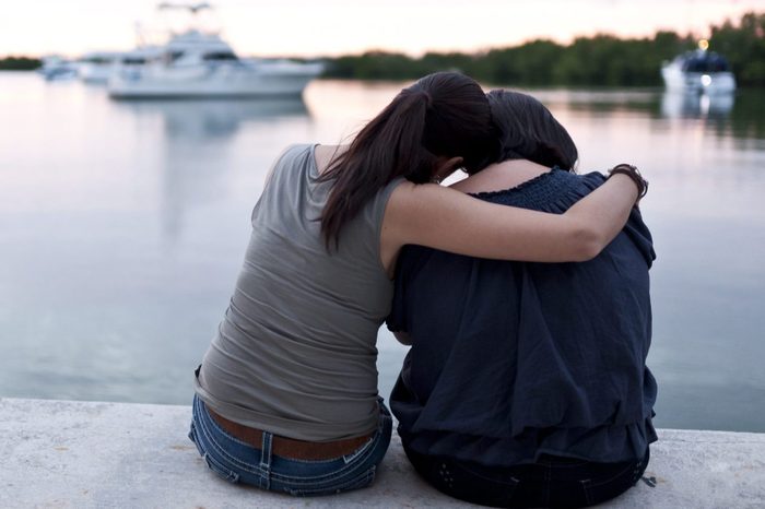 Comforting friend while sitting near a marina