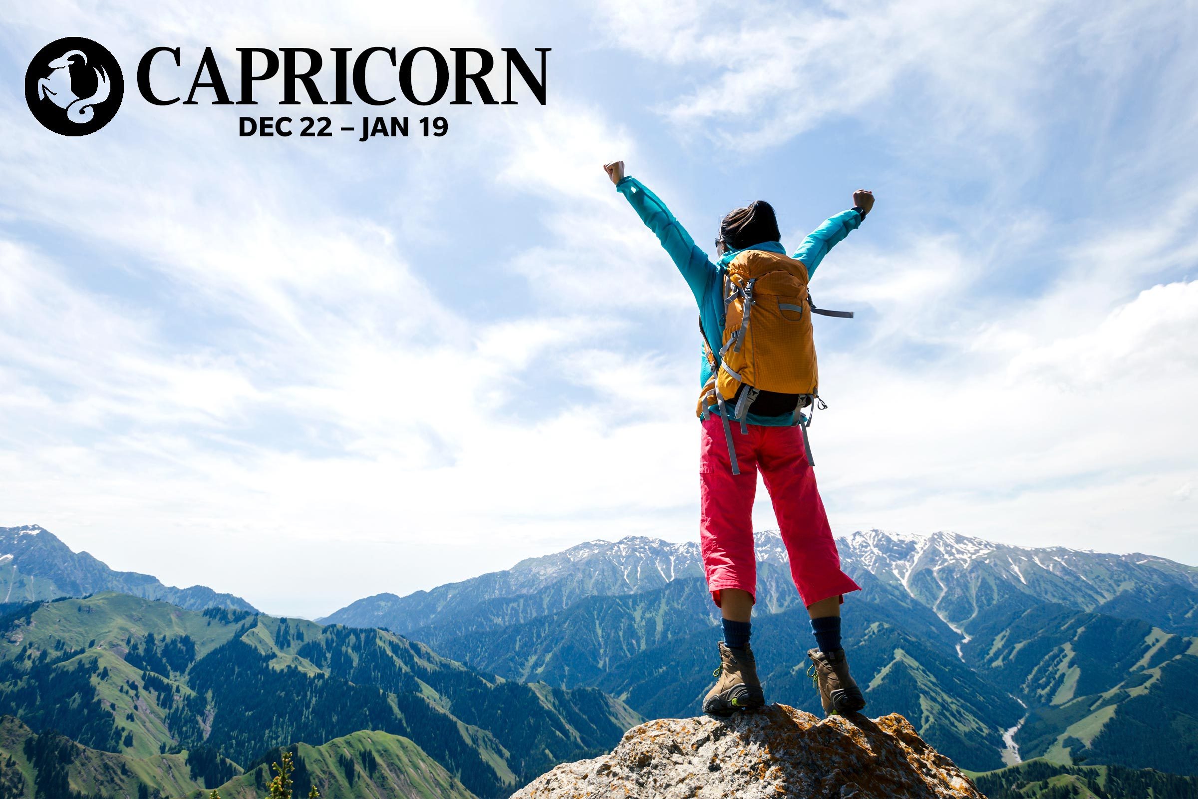 person celebrating at the top of a mountain