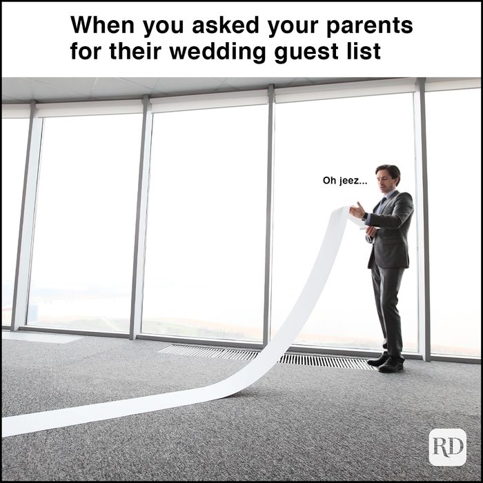 man reading very long paper roll in office