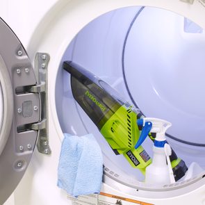 open dryer door with cleaning supplies inside