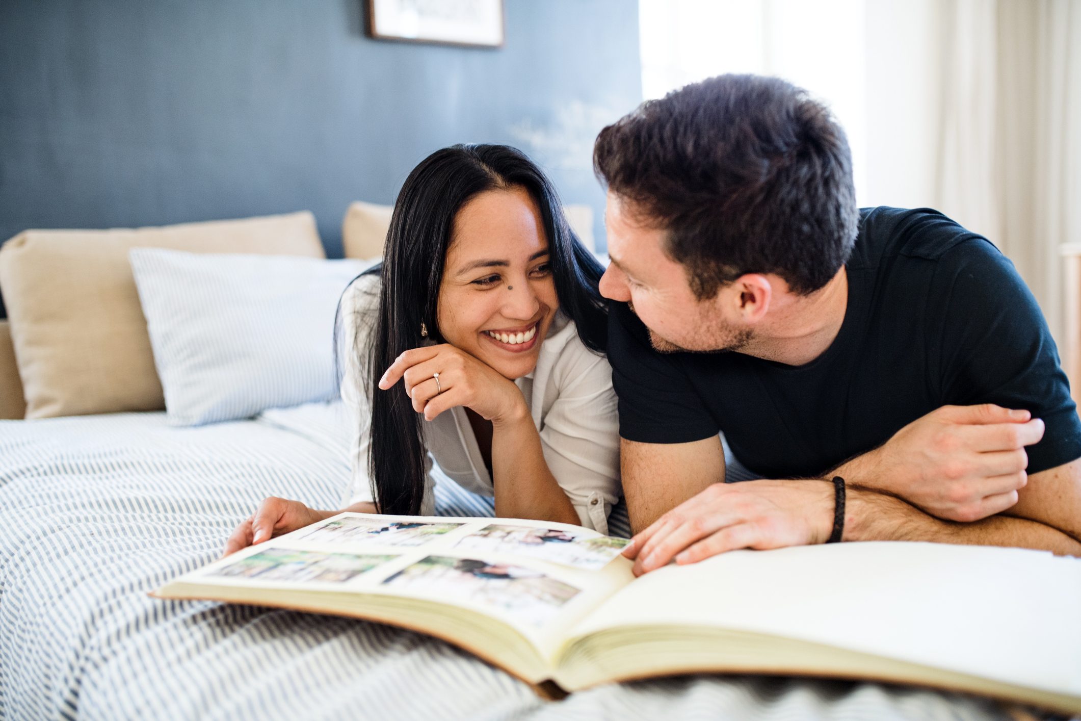 young couple making a photo album at home