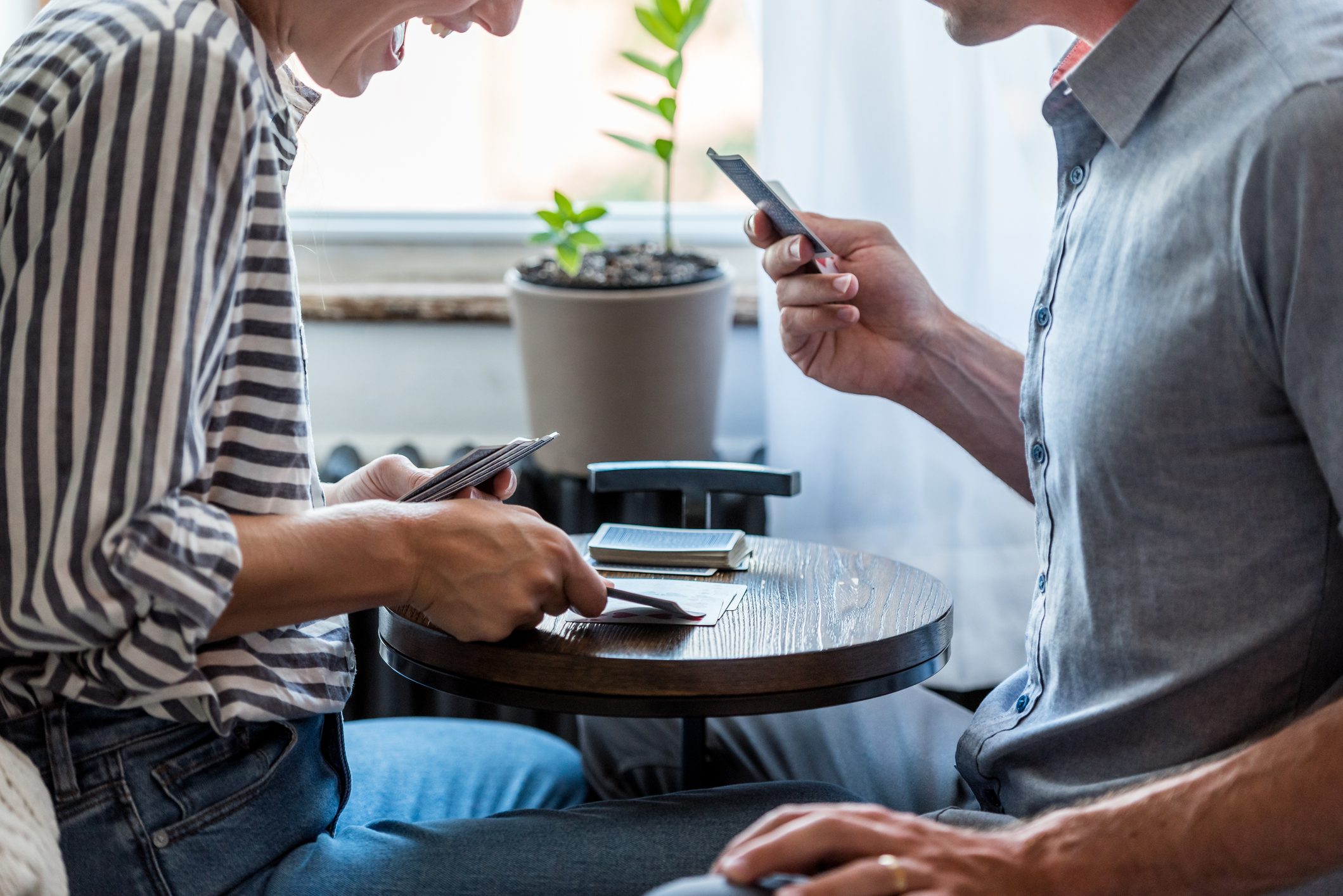 A young couple playing cards together at home