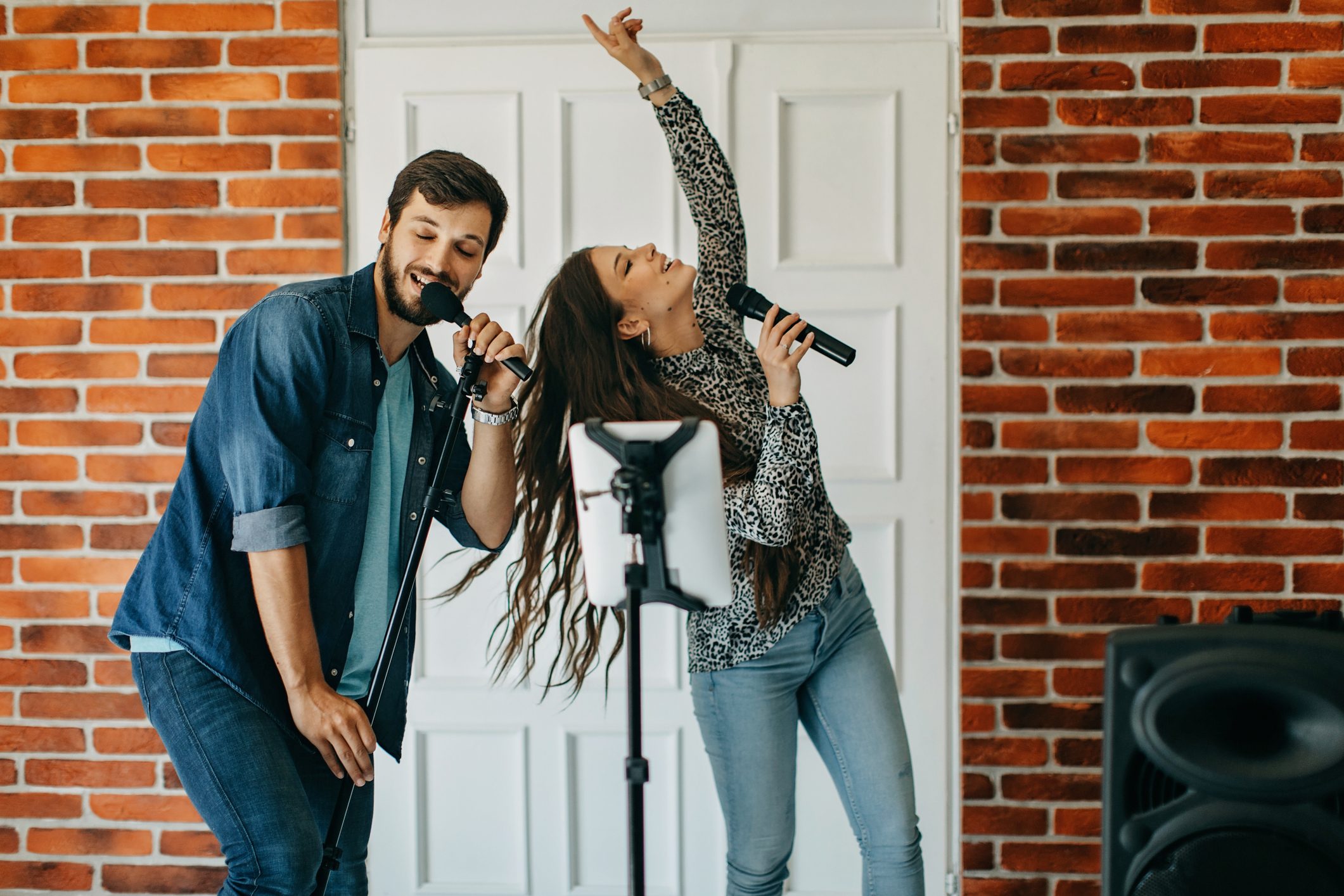 Young couple singing karaoke at home