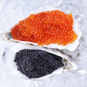 black and orange caviar in oyster shells on ice