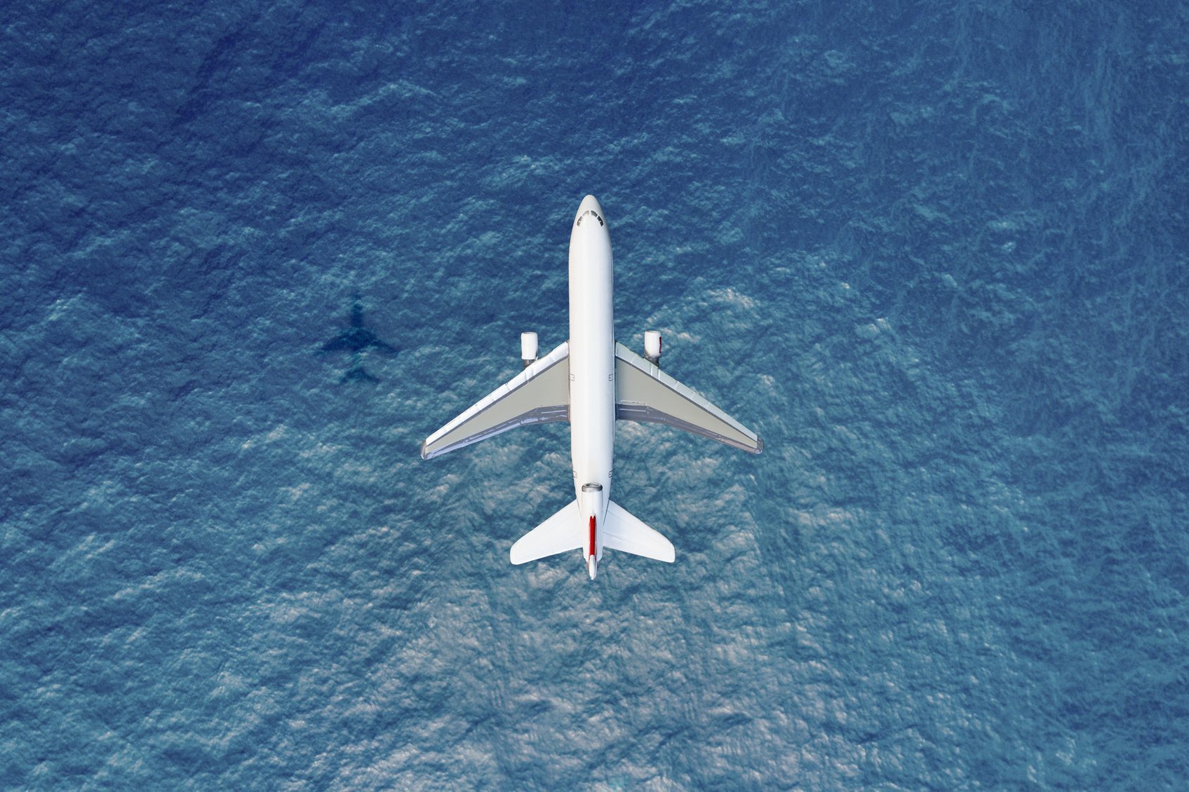 overhead view of an Airplane flies over water