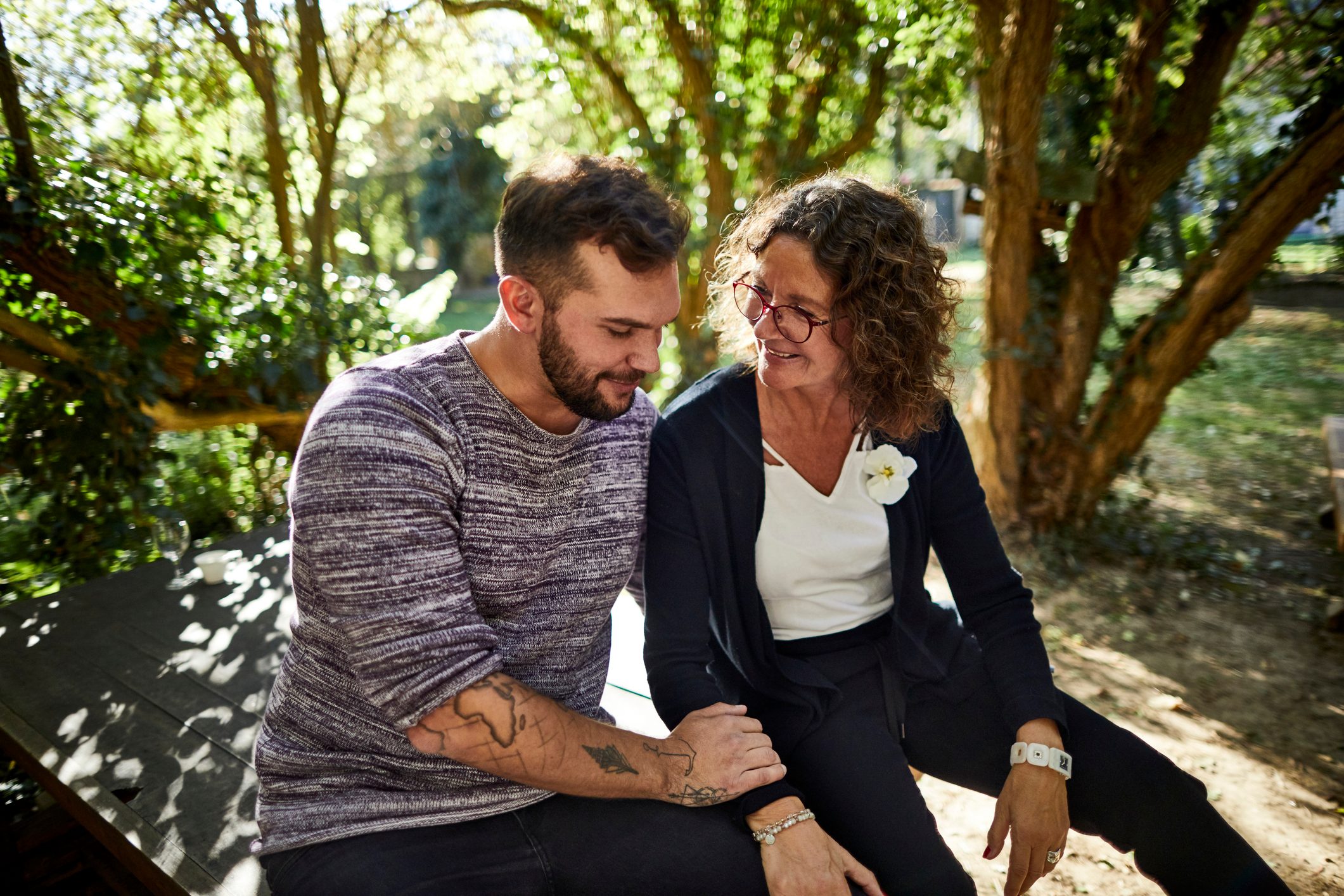 Mother and adult son sitting in garden