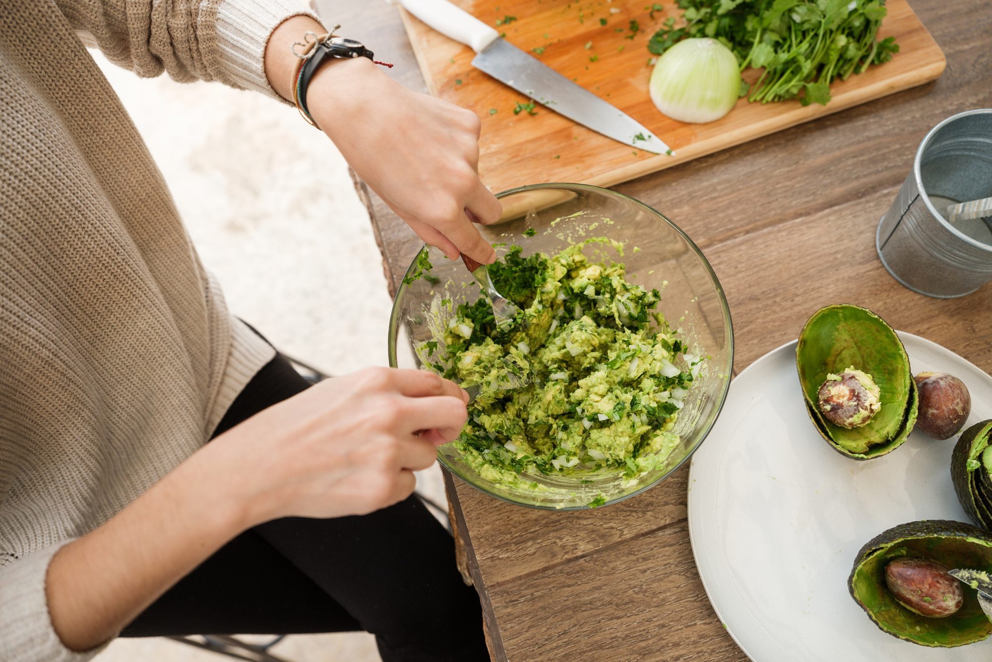 Young woman making guacamole