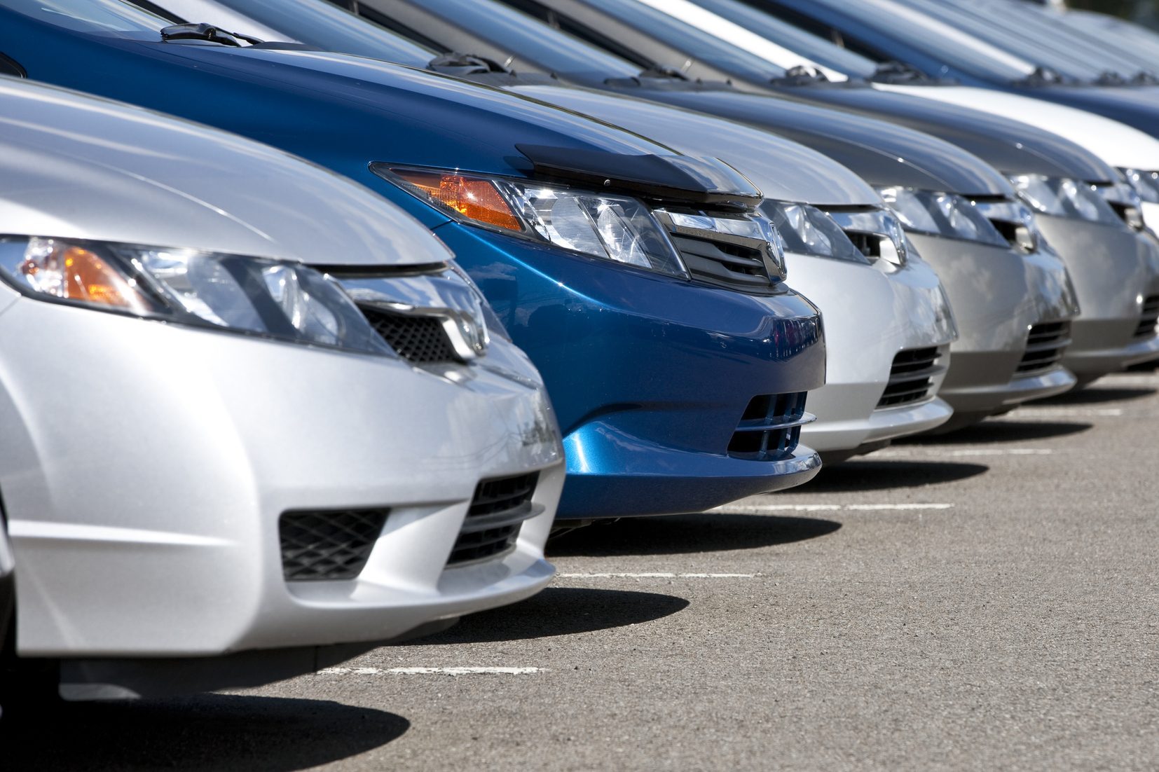 Line of compact cars at a dealership.