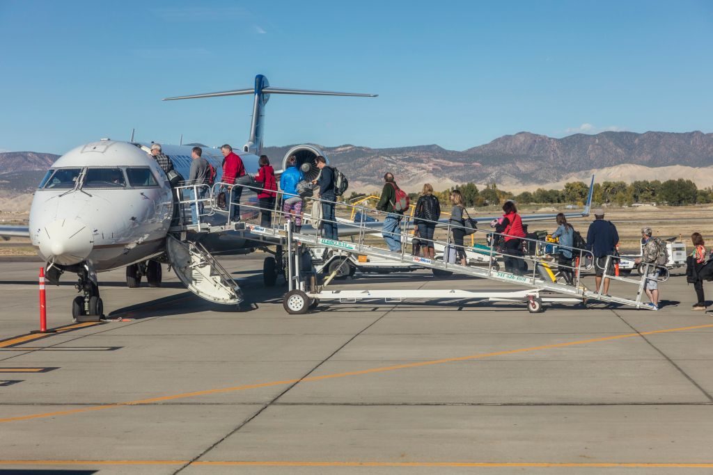 Passengers climbing stairs to board airplane 