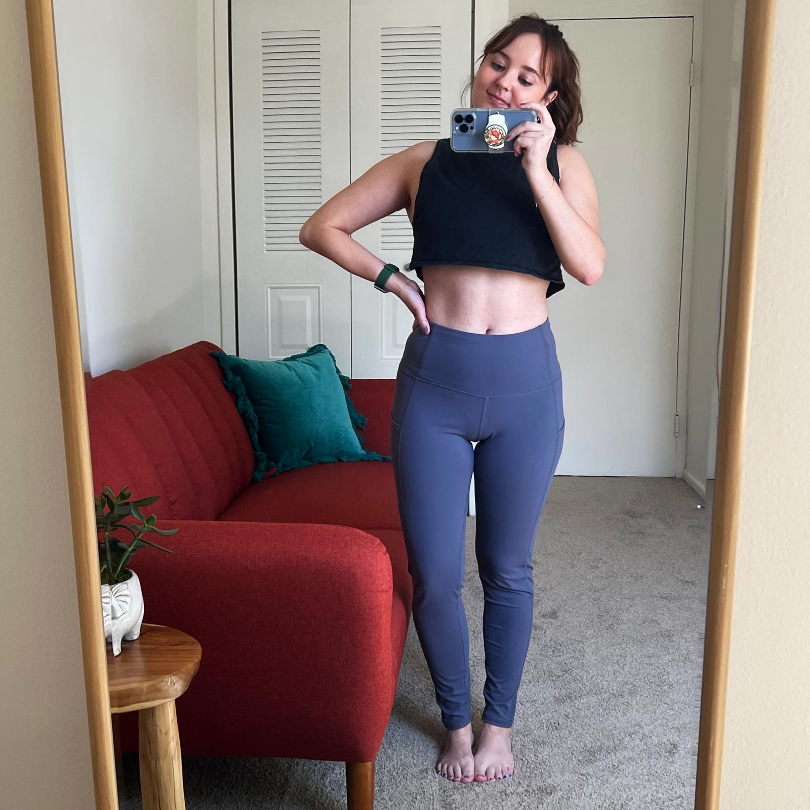 woman wearing leggings taking picture of herself in a mirror