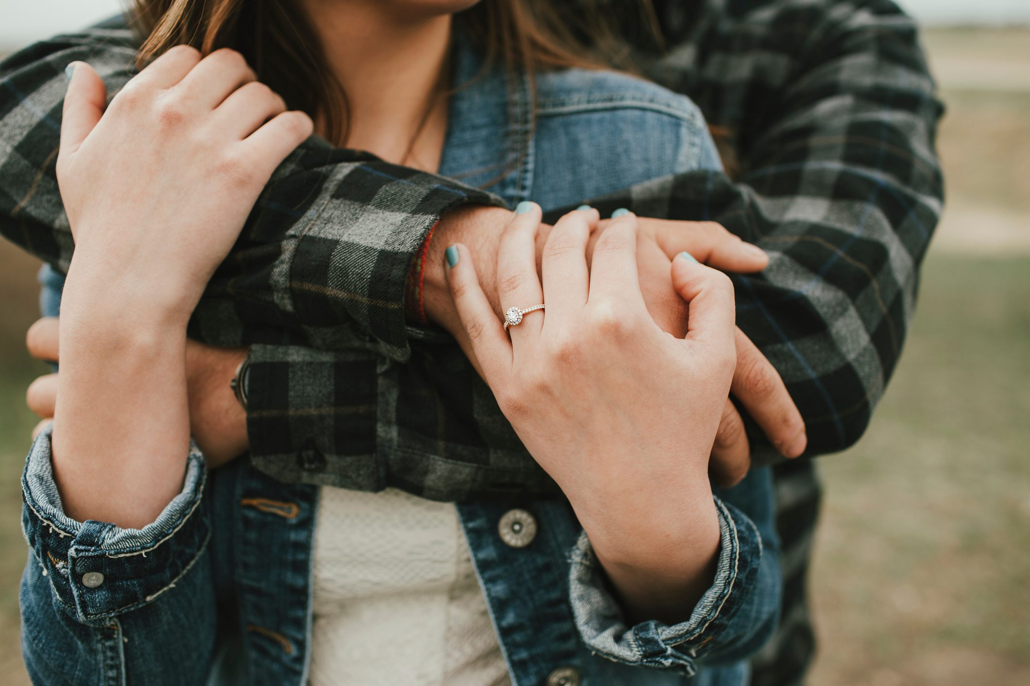 Man Hugging Woman with Engagement Ring